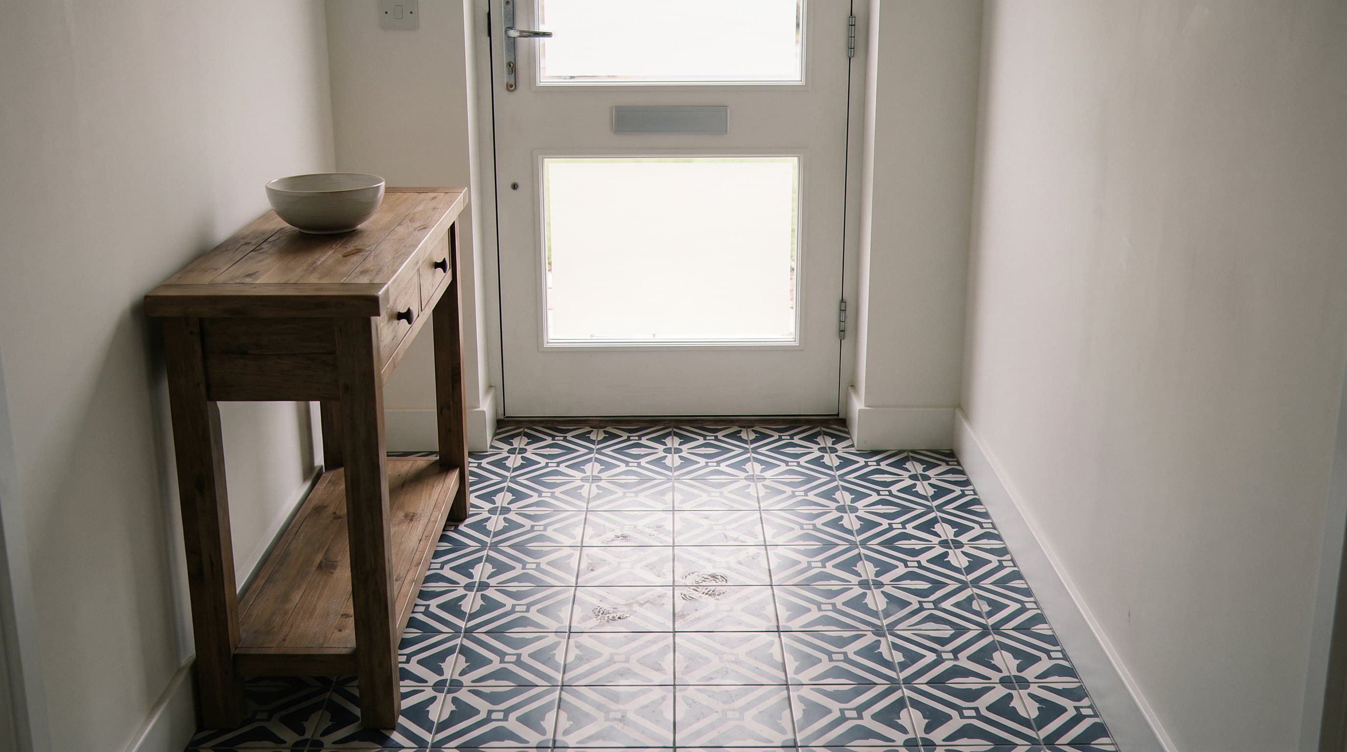 Patterned tile entry hallway with a console table