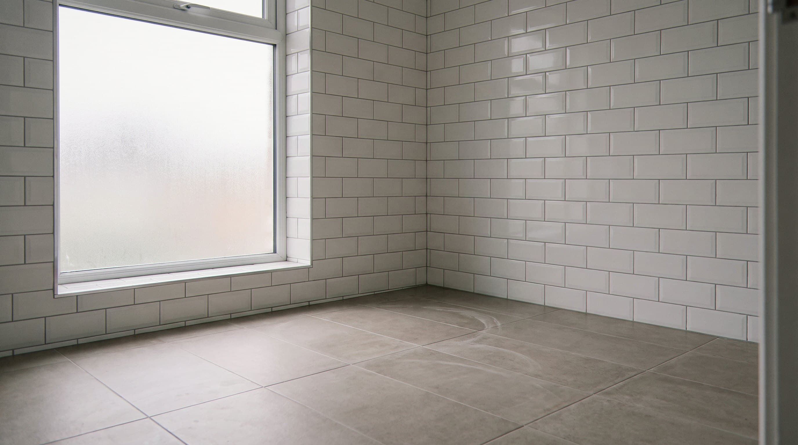 Corner of a bathroom in white beveled subway tile